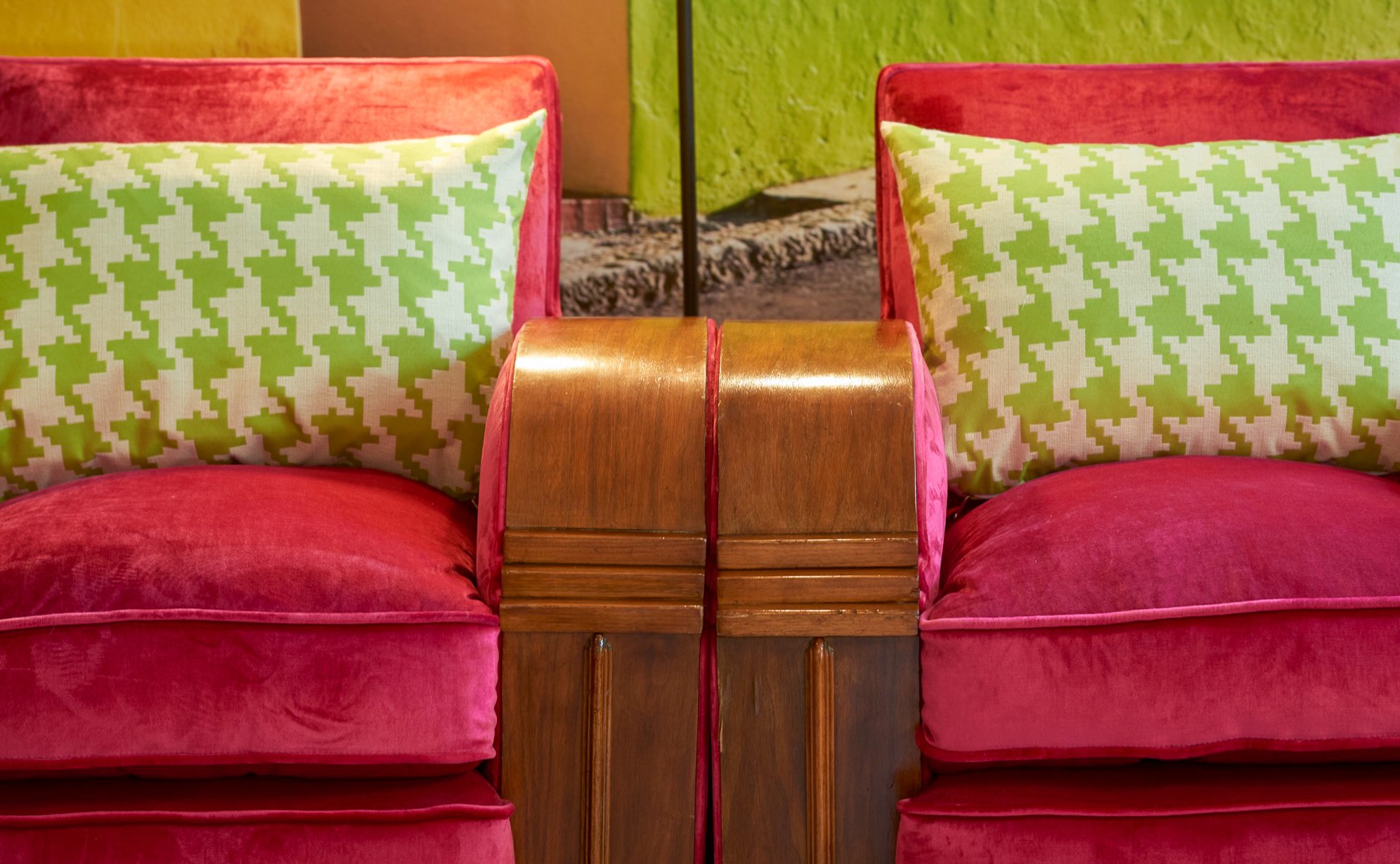 The pink velvet sofas and their houndstooth cushions