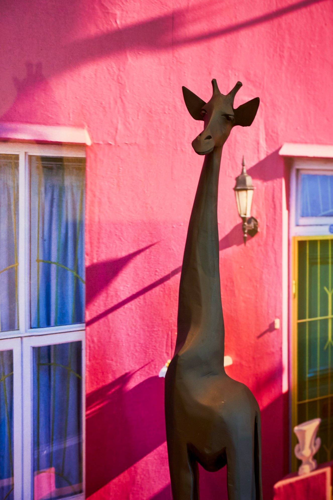 A carved giraffe against the Bo-Kaap mural